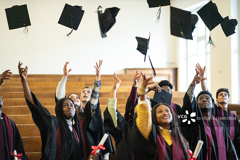 毕业生将帽子抛向空中图片素材