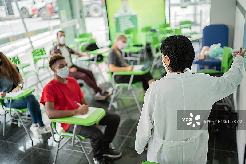 老师在教室里戴着口罩授课图片素材