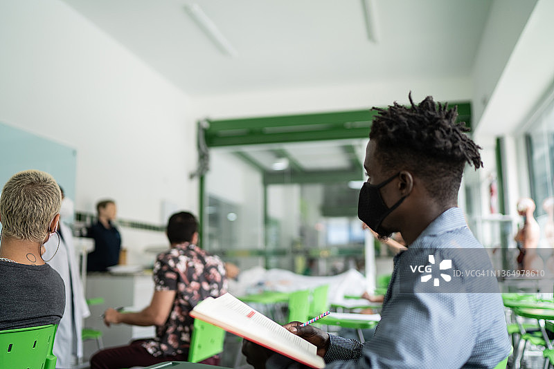 教室里戴口罩的年轻学生图片素材