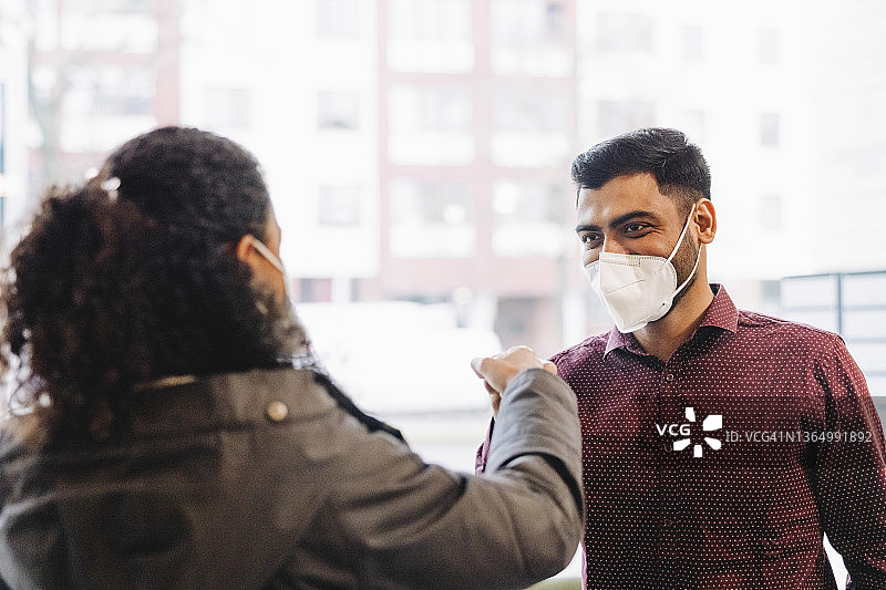 工作中，同事们互相用碰拳的方式打招呼图片素材