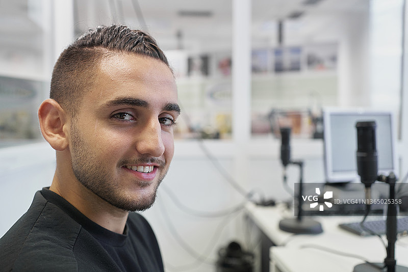 年轻男子在麦克风前微笑接受采访特写图片素材