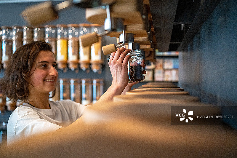 年轻女人在有机食品店购物图片素材