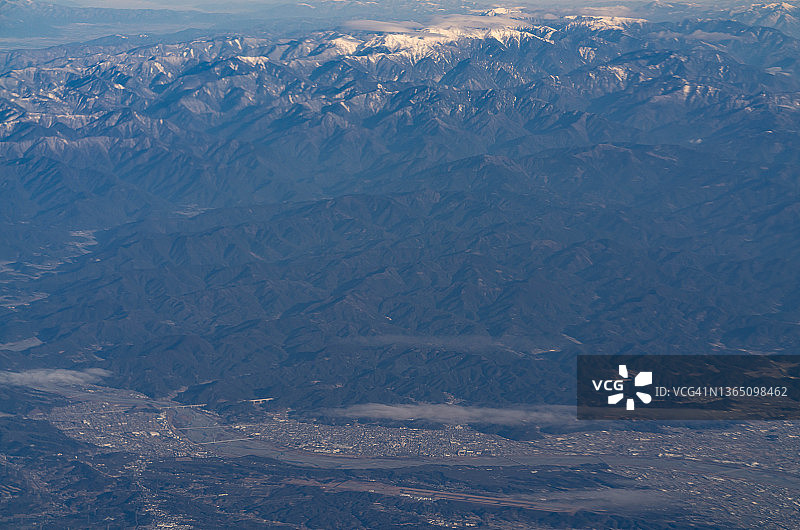 从飞机上俯瞰日本静冈县白雪皑皑的赤石山脉和岛田市图片素材