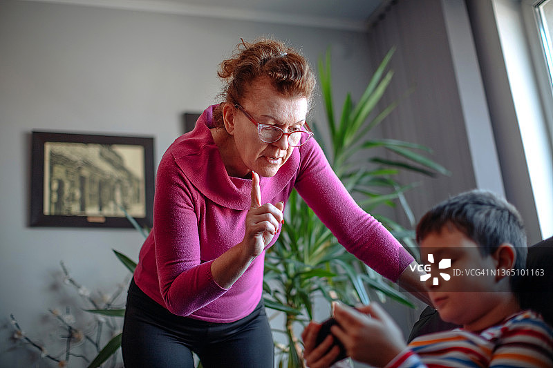 母亲训斥玩电子产品的孩子图片素材