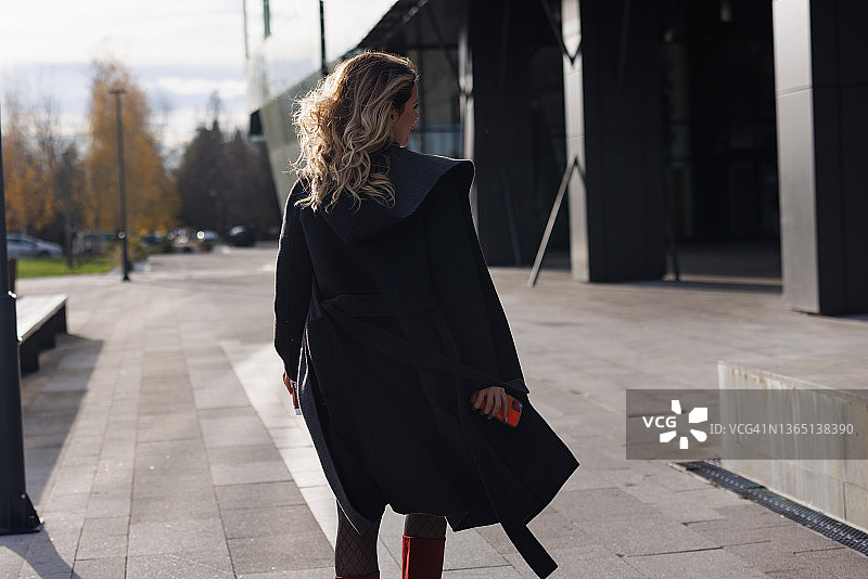 优雅年轻女子在城市中行走图片素材