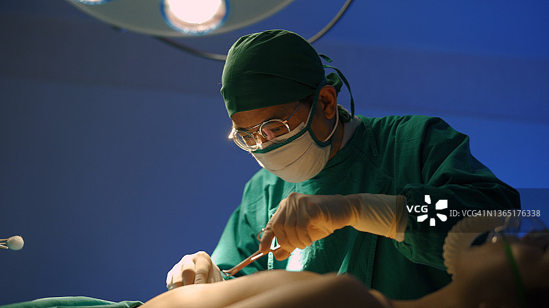年长的男外科医生给病人做手术图片素材