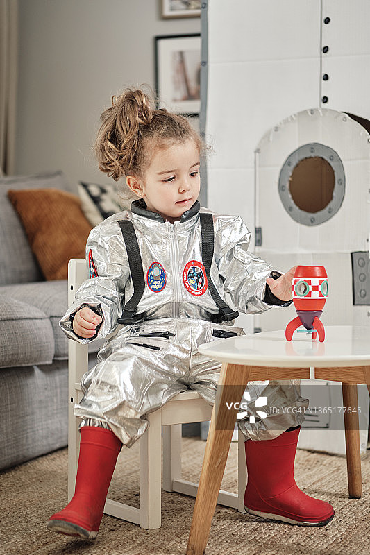 装扮成宇航员的女孩建造了一艘宇宙飞船图片素材
