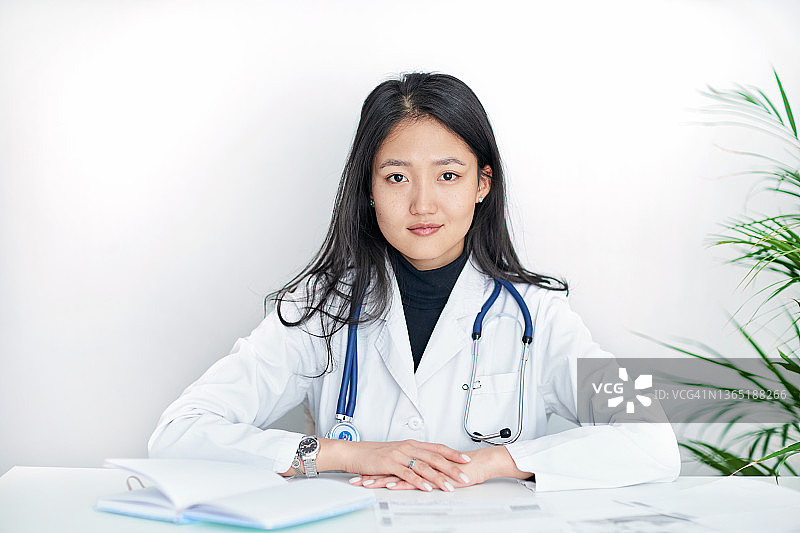 白色背景上身穿白大褂的年轻女医生肖像图片素材