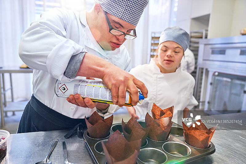 患有唐氏综合征的学生在厨房烤松饼图片素材
