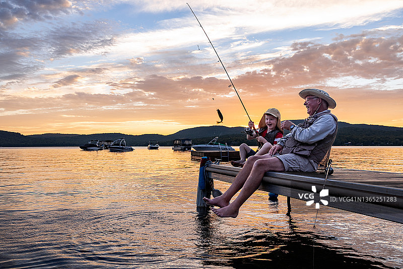 夏日祖孙日落时分钓鱼图片素材