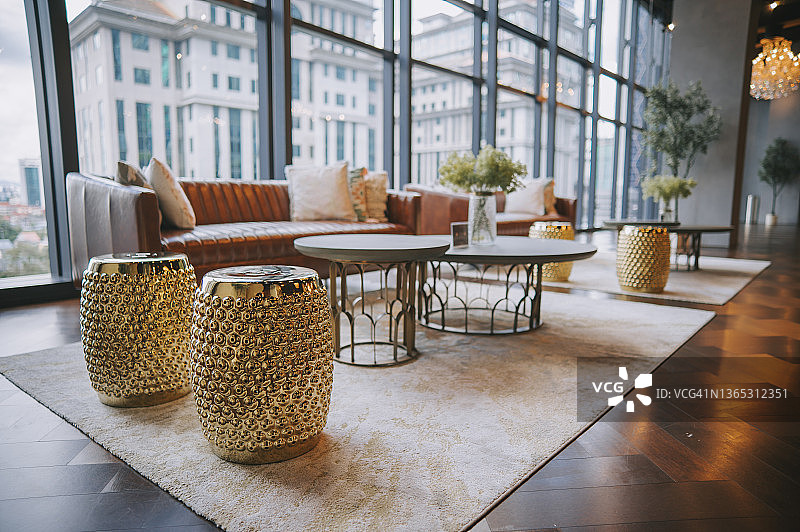 休息室，配有沙发，地毯和咖啡桌，背景是城市景观大堂区域的窗户图片素材