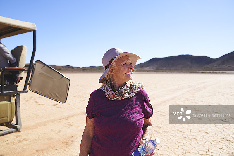 快乐的妇女在南非阳光明媚的干旱沙漠狩猎图片素材