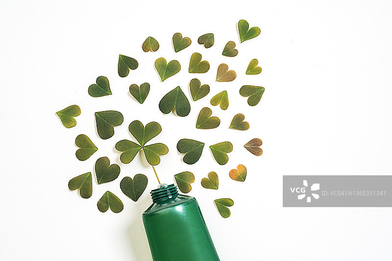 有机保湿面霜或护手霜绿色软管，叶子心形图案凝胶。情人节礼物概念。图片素材