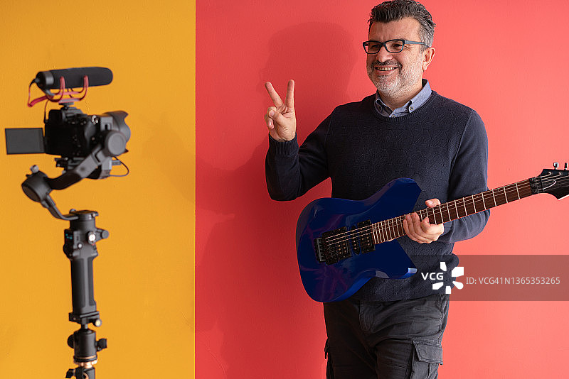 视频博主在工作室在线教吉他弹奏图片素材