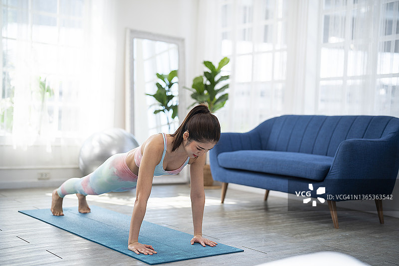 运动型女孩在家做推举运动图片素材