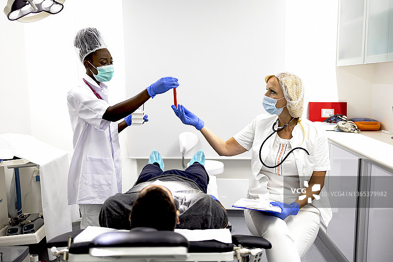 两位医生使用适当的设备和防护口罩检查冠状病毒患者图片素材