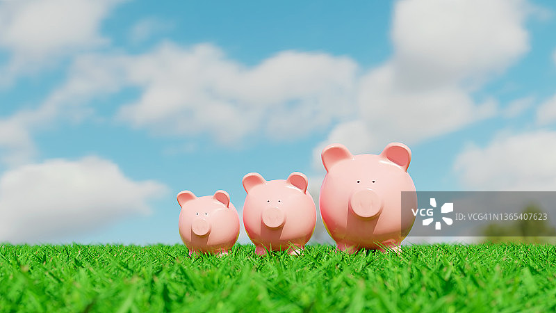 阳光下，粉色小猪储蓄罐立在绿草地上图片素材