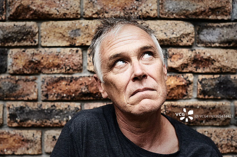 50多岁的英俊男人抬头，显得恐惧和怀疑图片素材
