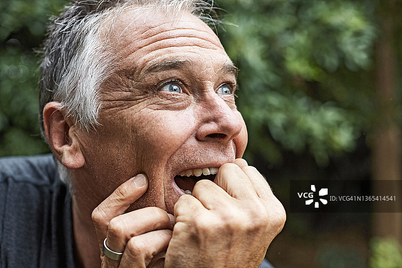 50多岁的英俊男人在花园里感到惊喜图片素材