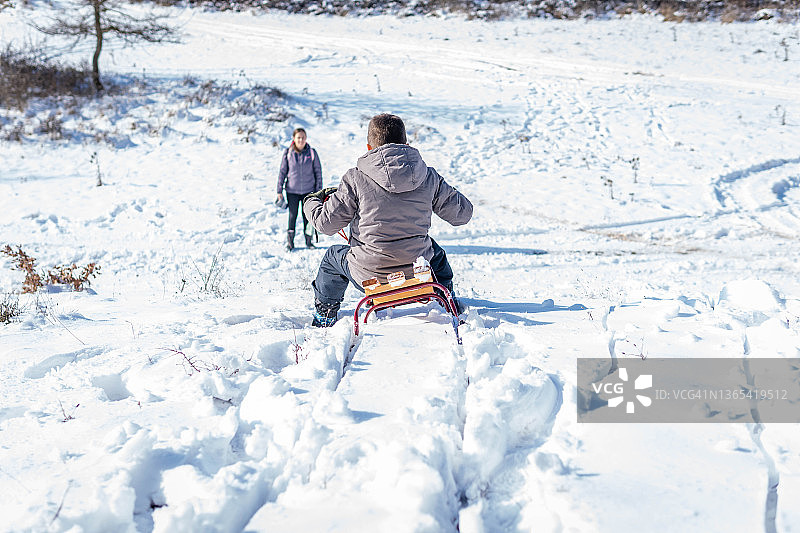 男孩在雪橇上玩耍图片素材