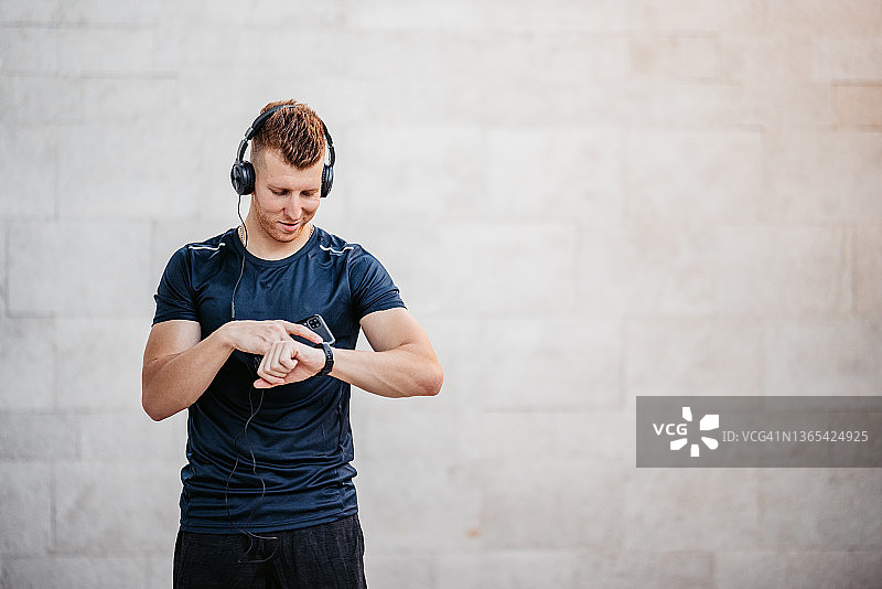查看健身追踪器的年轻男人图片素材
