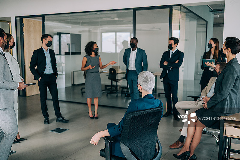 戴防护口罩的商务人士在办公室开会图片素材