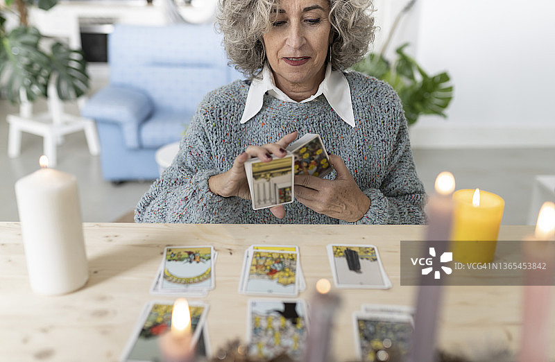 老年妇女在家中桌旁阅读塔罗牌图片素材