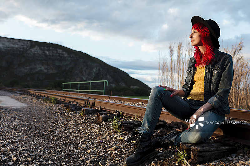 坐在铁轨上的沉思女人图片素材