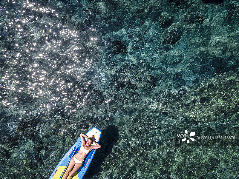 在假期中，无忧无虑的女人穿着比基尼在海上放松身心图片素材