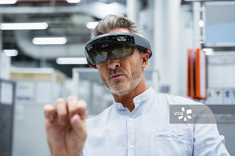 在工厂使用增强现实眼镜的商人图片素材