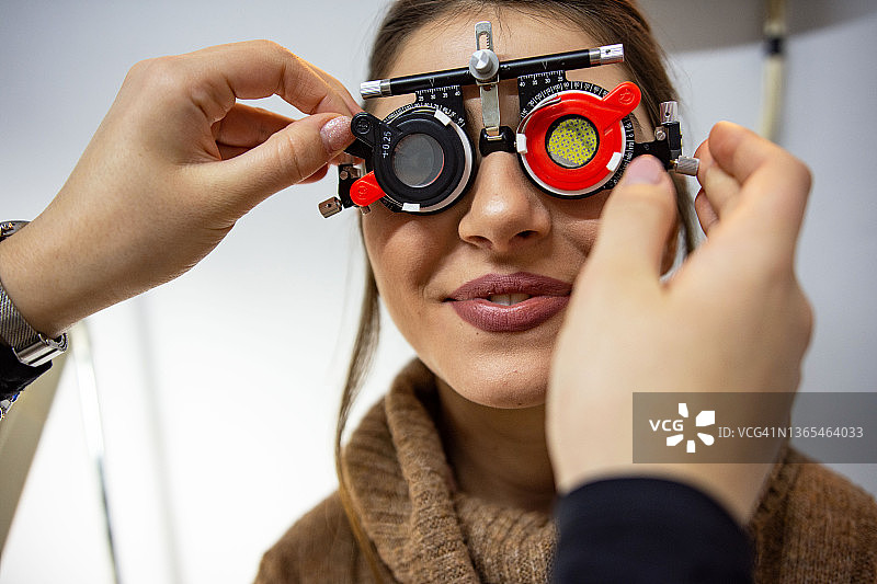 年轻女人使用眼科检查设备进行眼科检查图片素材