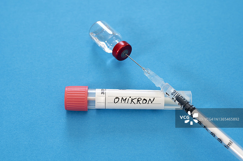 蓝色背景下的医用注射器与奥密克戎拭子管图片素材