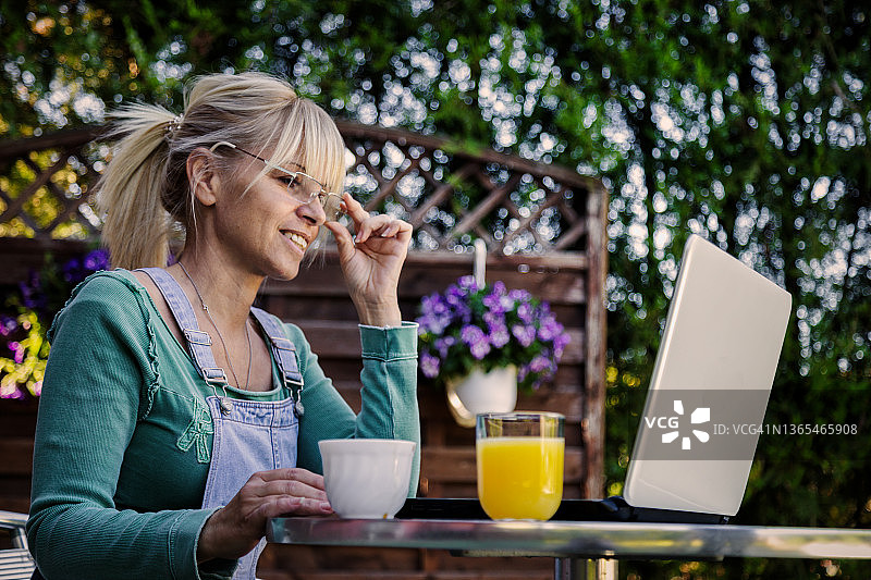 在花园里用笔记本电脑工作的女人图片素材