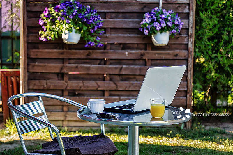 在花园里用笔记本电脑工作的女人图片素材