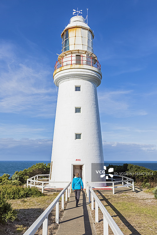 澳大利亚维多利亚州奥特威海角，女游客参观大奥特威国家公园的奥特威海角灯塔图片素材