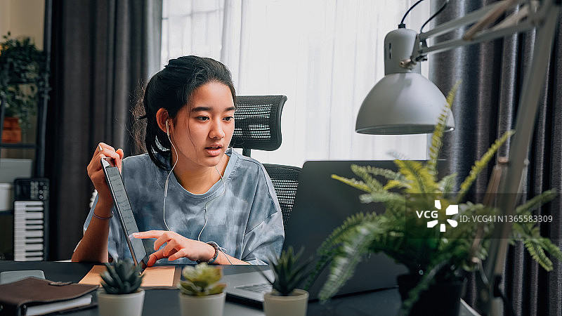 少女在笔记本电脑上看在线学习课程，与老师进行家庭视频通话图片素材