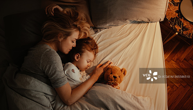 充满爱意的母女在晚上一起睡觉图片素材