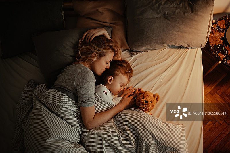 充满爱意的母女在晚上一起睡觉图片素材