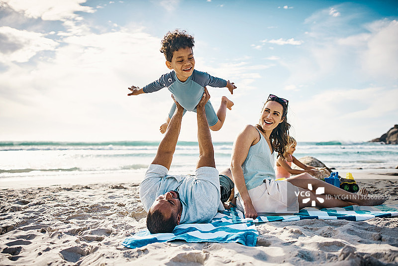 男子在海滩上和儿子玩耍图片素材