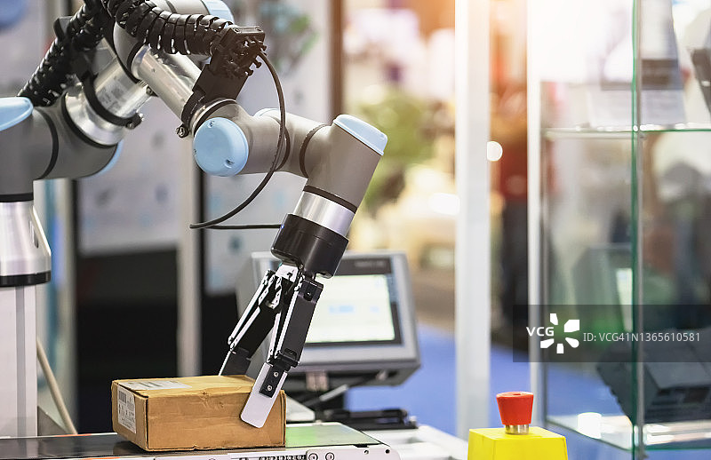 机械臂在仓库中搬运纸箱图片素材