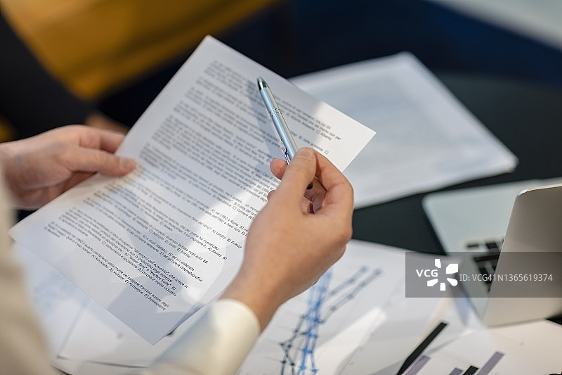 在办公室里拿着笔和文件的商人图片素材