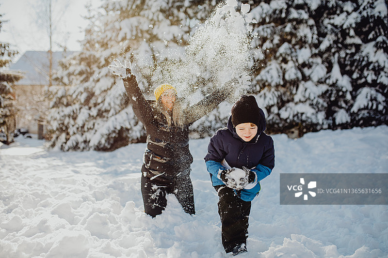 男孩和妈妈在冬日里玩雪图片素材