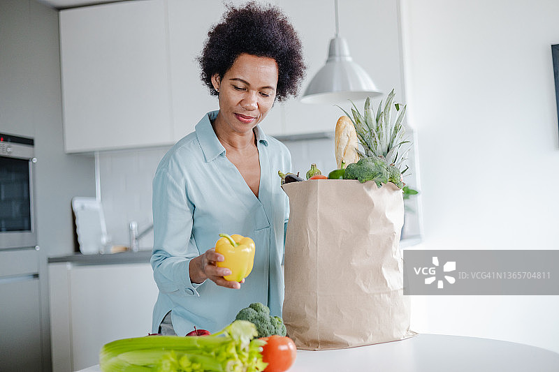 女人打开装满食品杂货的袋子图片素材