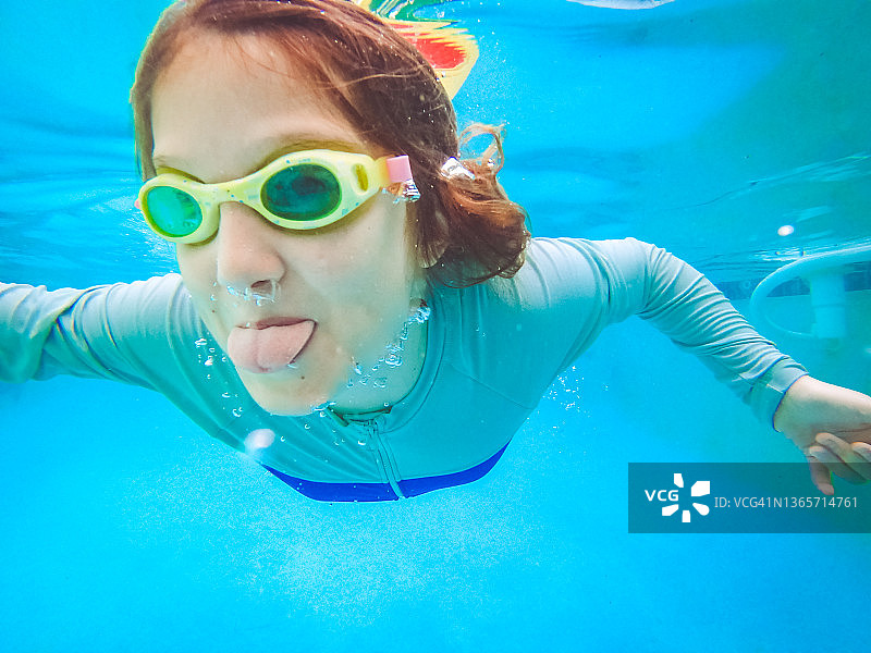 在泳池中戴着泳镜游泳的女孩，有趣的户外活动图片素材
