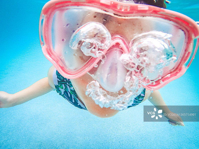 趣味儿童在游泳池里戴着泳镜在水下嬉戏图片素材