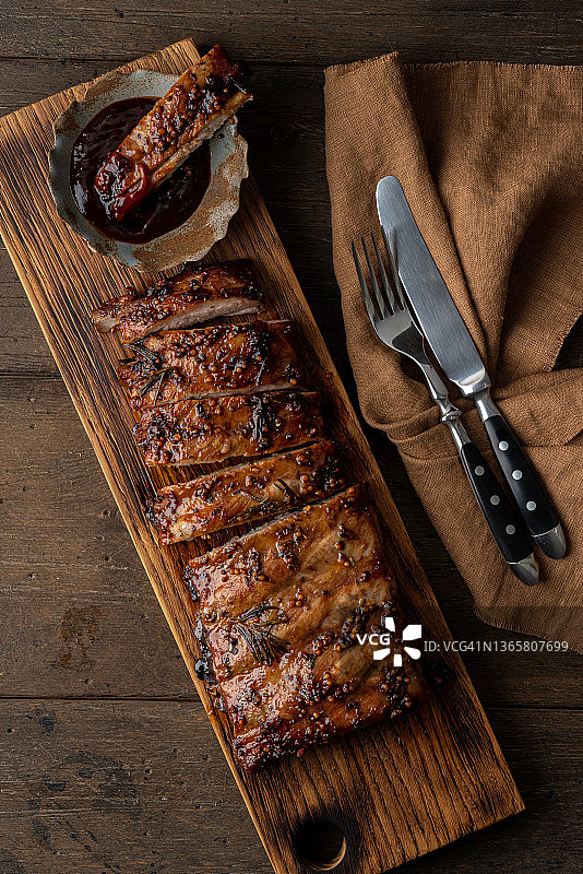 用迷迭香、芥末、胡椒和红酱烹制的鲜嫩多汁带骨猪肉图片素材