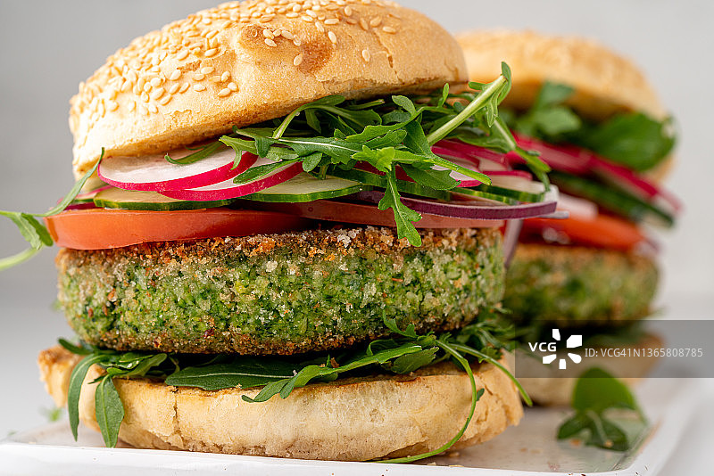 素食汉堡特写，含蔬菜馅饼和切片蔬菜的新鲜纯素小吃图片素材