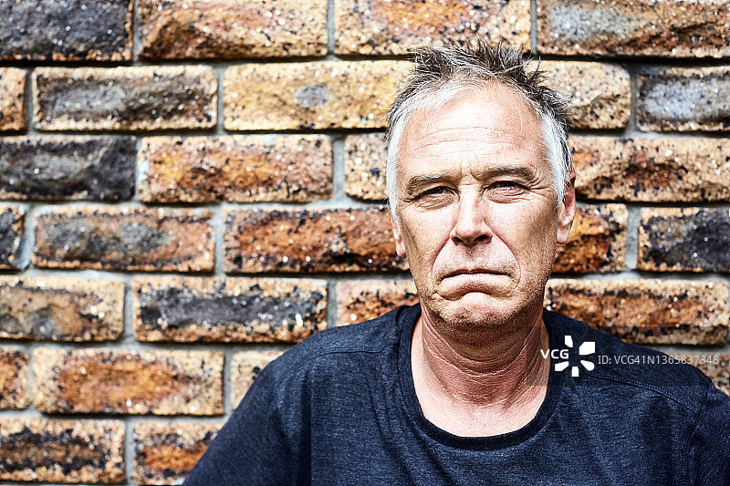 表情严肃不悦， grimly盯着镜头的男人图片素材