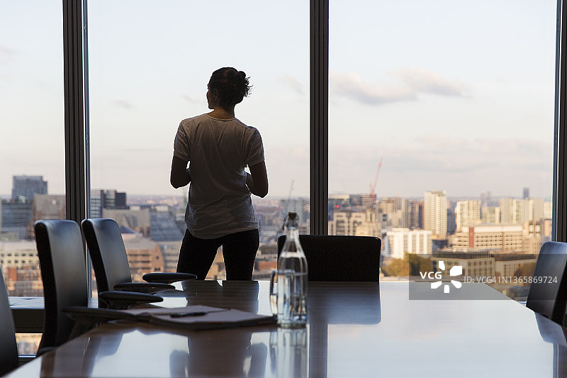 眺望高层办公室窗外的沉思的女商人图片素材