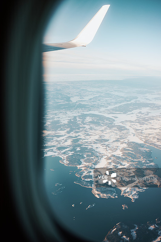 飞机飞过斯堪的纳维亚半岛，从飞机舷窗观看图片素材